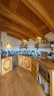 a large kitchen with wooden floors and wooden ceilings at Fount de Cousteno in Limbrassac