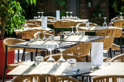 an array of tables and chairs at an outdoor restaurant at LOGIS Hôtel Restaurant Le Clos Fleuri in Castelnaudary