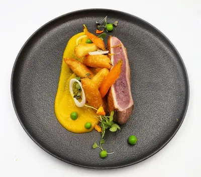 a plate of food with a ham and french fries at LOGIS Hôtel Restaurant Le Clos Fleuri in Castelnaudary