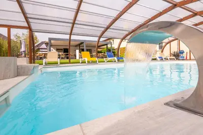 a pool with a water fountain in the middle at LOGIS Hôtel Restaurant Le Clos Fleuri in Castelnaudary