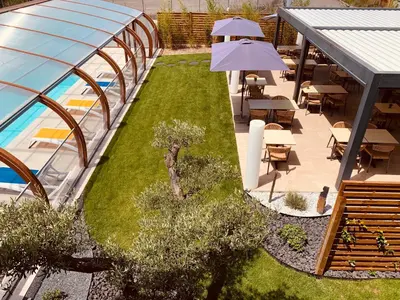 an outdoor patio with a garden and a swimming pool at LOGIS Hôtel Restaurant Le Clos Fleuri in Castelnaudary