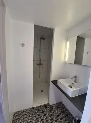a white bathroom with a sink and a shower at Contact Hôtel Le Minervois - Hôtel & Restaurant Au nord de Carcassonne in Caunes-Minervois