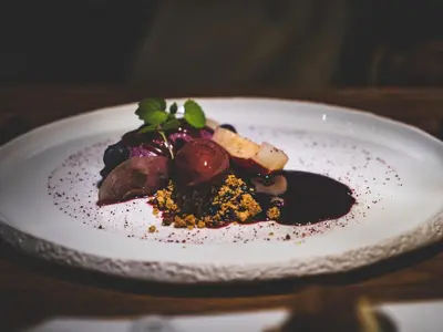 a white plate with a dessert on a table at Domaine Riberach - Restaurant étoilé - Spa - Piscine naturelle - Vignoble bio in Bélesta