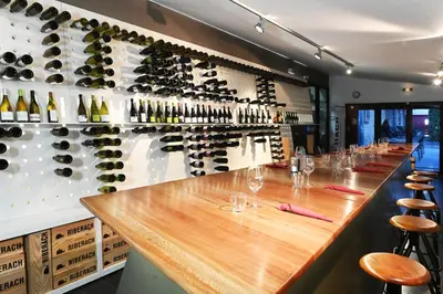 a bar with wine bottles on the wall at Domaine Riberach - Restaurant étoilé - Spa - Piscine naturelle - Vignoble bio in Bélesta