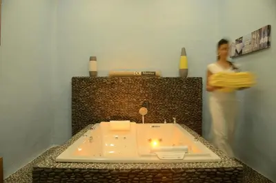 a man standing in a bathroom with a bath tub at Domaine Riberach - Restaurant étoilé - Spa - Piscine naturelle - Vignoble bio in Bélesta