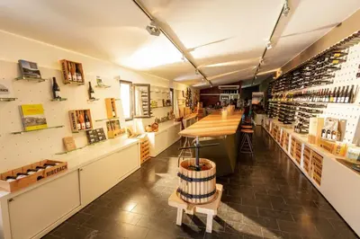 a wine store with a counter with wine bottles at Domaine Riberach - Restaurant étoilé - Spa - Piscine naturelle - Vignoble bio in Bélesta
