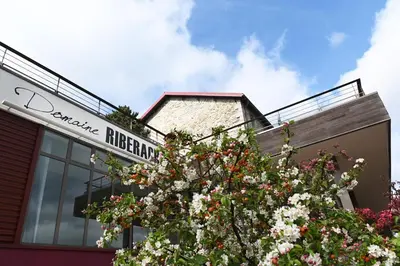 a sign on the side of a building with flowers at Domaine Riberach - Restaurant étoilé - Spa - Piscine naturelle - Vignoble bio in Bélesta