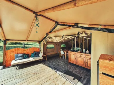 a room with a tent with a bed and a table at Camping des vignes in Dun