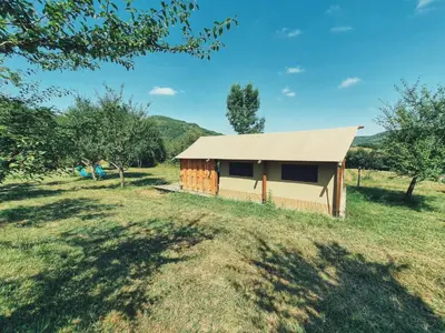 a small shed in a field with trees at Camping des vignes in Dun