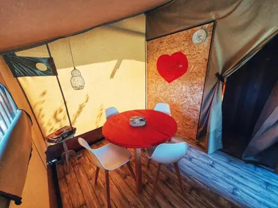 a table in a tent with a red heart on the wall at Camping des vignes in Dun