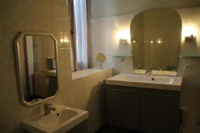 a bathroom with a sink and a mirror at La Maison du Soleil in Saint-Gaudéric