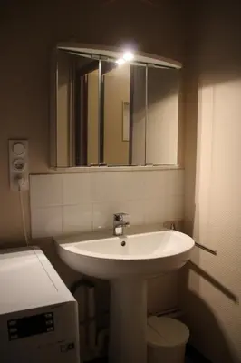 a bathroom with a white sink and a mirror at La Maison du Soleil in Saint-Gaudéric