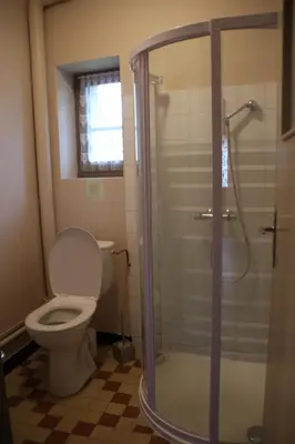 a bathroom with a toilet and a glass shower at La Maison du Soleil in Saint-Gaudéric