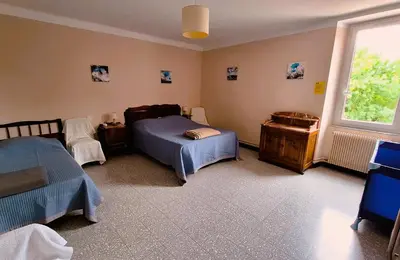 a bedroom with two beds and a window at La Maison du Soleil in Saint-Gaudéric