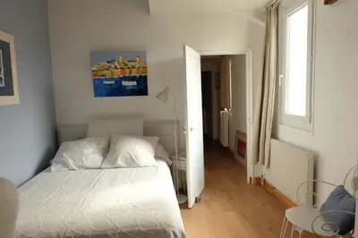 a bedroom with a white bed and a window at B&B Le Patio En Ville - Chambres d'hôtes in Narbonne