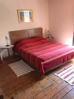 a bedroom with a large bed with a red blanket at Le Ribet in Lempaut