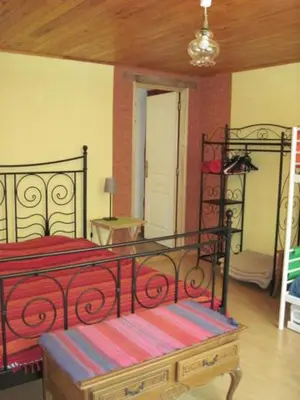a bedroom with a bed with a red and black frame at Le Ribet in Lempaut