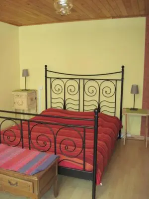 a bedroom with a red bed and two night stands at Le Ribet in Lempaut