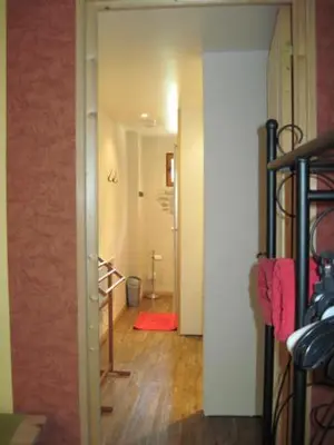 a hallway with a bathroom with a red rug in a room at Le Ribet in Lempaut