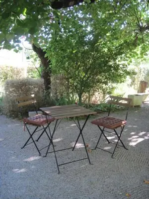 a picnic table and two chairs under a tree at Le Ribet in Lempaut