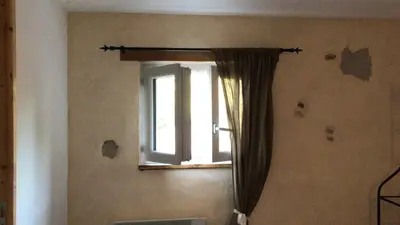 a window with a curtain in a room at Le Ribet in Lempaut