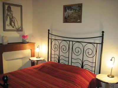 a bedroom with a bed with two tables and two lamps at Le Ribet in Lempaut