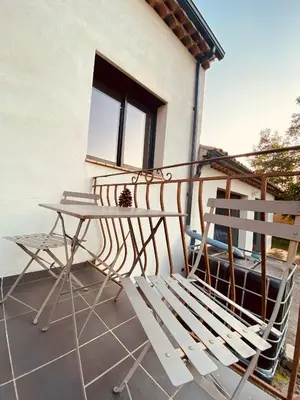 a white chair and a table on a balcony at Gite CATHARE en OCCITANIE in Espéraza