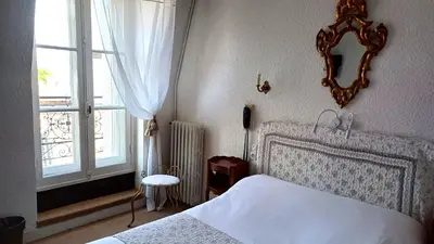 a bedroom with a white bed and a window at Hotel Montsegur in Carcassonne