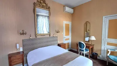 a hotel room with a bed and a mirror at Hotel Montsegur in Carcassonne