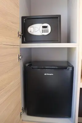 a small refrigerator in a cabinet with a microwave at Hotel Restaurant Rose des Pyrénées in Belvianes-et-Cavirac