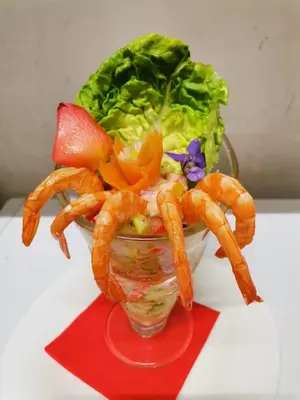 a glass bowl filled with shrimp and lettuce on a table at Hotel Restaurant Rose des Pyrénées in Belvianes-et-Cavirac