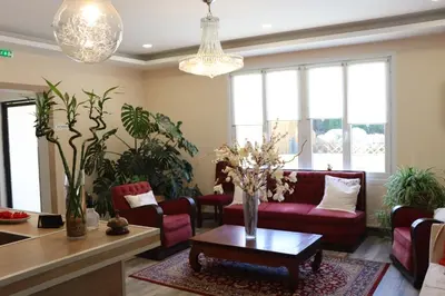 a living room with a red couch and a table at Hotel Restaurant Rose des Pyrénées in Belvianes-et-Cavirac
