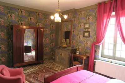 a bedroom with a mirror and a pink bed at Château de Puichéric in Puicheric