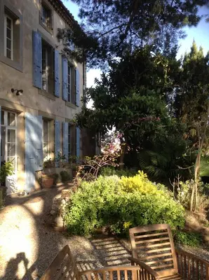 a wooden bench sitting in front of a building at Château de Puichéric in Puicheric