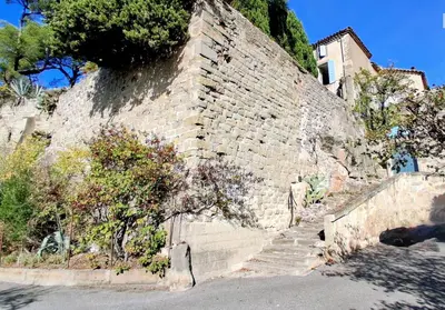 a brick wall with stairs in front of a building at Château de Puichéric in Puicheric