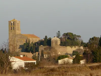 a church and a village with a church tower at Château de Puichéric in Puicheric