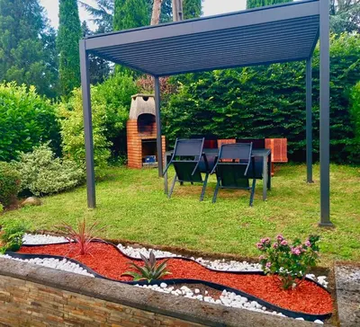 a backyard with a table and chairs under a pergola at La Prade des 