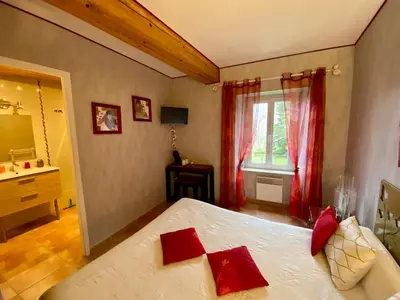 a bedroom with a bed with red pillows on it at La Prade des 