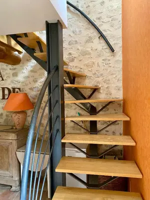 a spiral staircase in a house with a lamp at La Prade des 