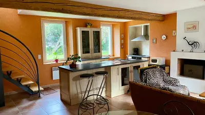 a kitchen with an island and a couch in a room at La Prade des 