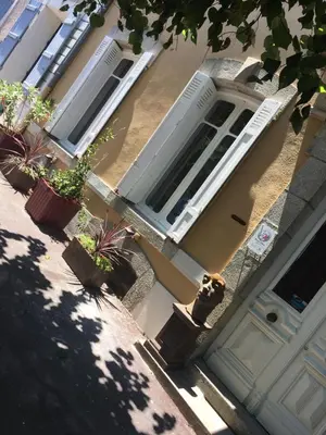 a house with a white door and potted plants at GUESTHOUSE La VILLAE in Mazamet