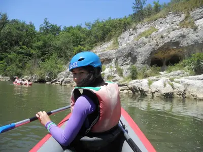 a woman is in a kayak on a river at Entre l'église et la place in Quillan