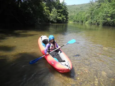 a woman in a kayak on a river at Entre l'église et la place in Quillan