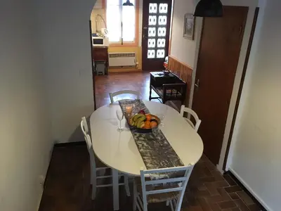 a white dining room table with a bowl of fruit on it at Entre l'église et la place in Quillan