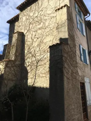 a building with two towers on the side of it at Entre l'église et la place in Quillan