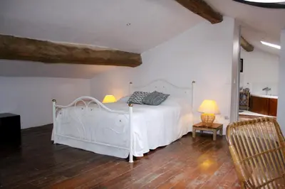 a bedroom with a white bed in a room at Gite La Luciole in Tourtrol