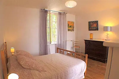 a bedroom with a bed and a dresser and a window at Gite La Luciole in Tourtrol