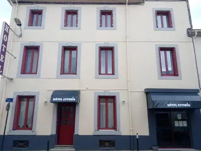 a white building with red doors and windows at Hotel Astoria in Carcassonne