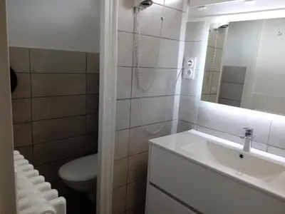 a bathroom with a sink and a toilet and a mirror at Hotel Astoria in Carcassonne