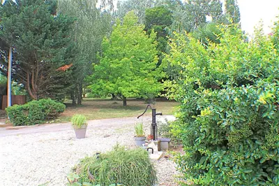 a garden with trees and plants and a gardenificialificialificialificialificialificialificial at Chambres d'hôtes La Luciole in Tourtrol